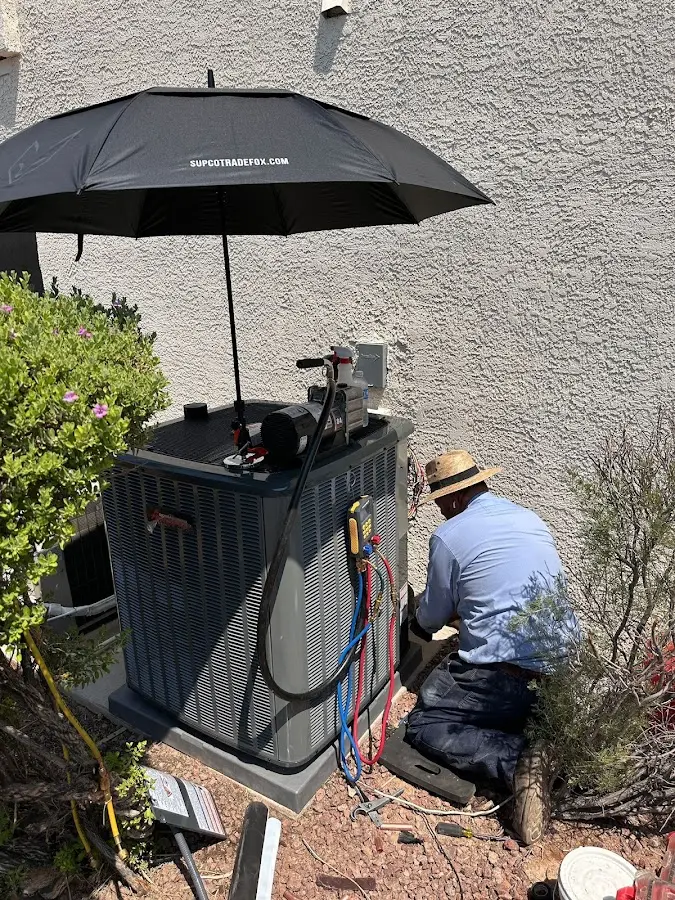 HVAC technician performing outdoor AC maintenance in Summit
