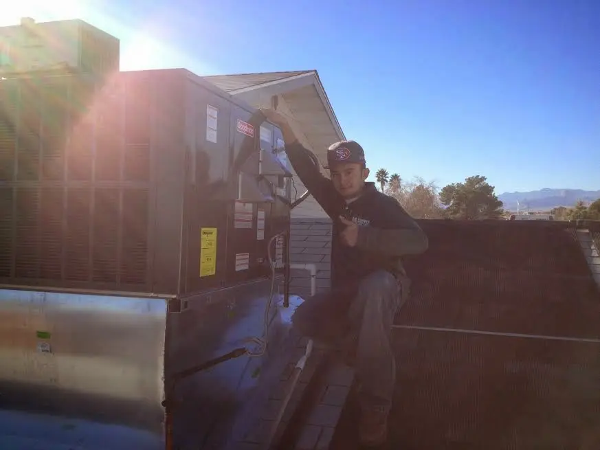 HVAC technician performing Heat Pump Repair on a rooftop unit in Summit